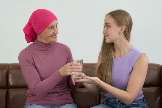 Jonge volwassen vrouwelijke kankerpatiënt tijd doorbrengen met haar dochter thuis.