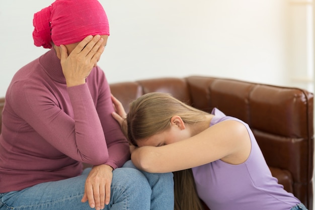 Jonge volwassen vrouwelijke kankerpatiënt tijd doorbrengen met haar dochter thuis.