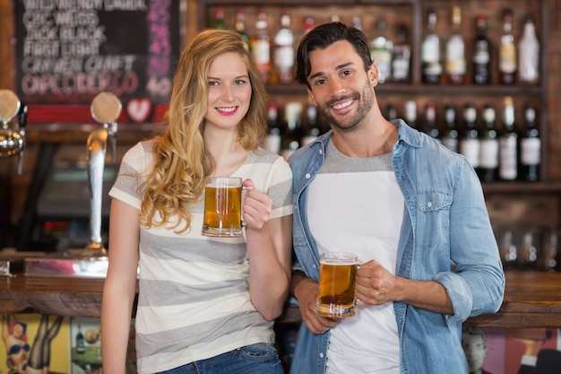 Jonge vrienden die bier houden bij bar