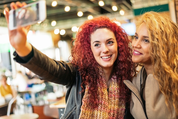 Jonge vrienden die een selfie maken met mobiele telefoon in een restaurantbar