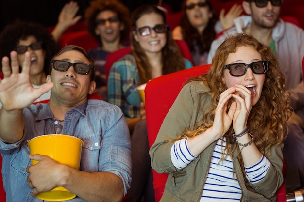 Foto jonge vrienden die op een 3d film letten