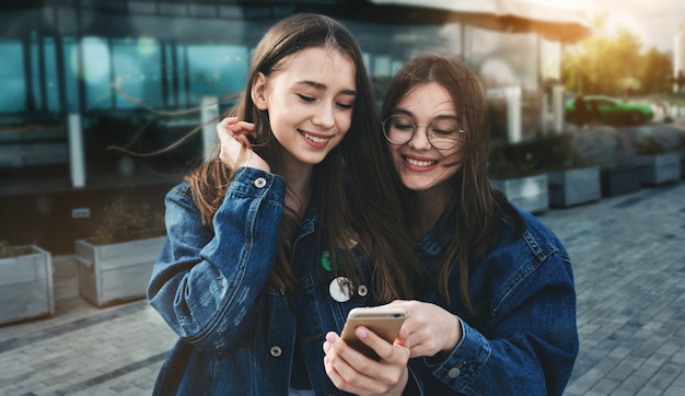 Jonge vrienden met plezier met smartphone in de lente