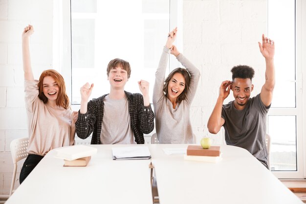 Jonge vrienden studenten zitten in de klas binnenshuis