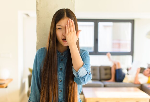 Jonge vrij aziatische vrouw die slaperig kijkt