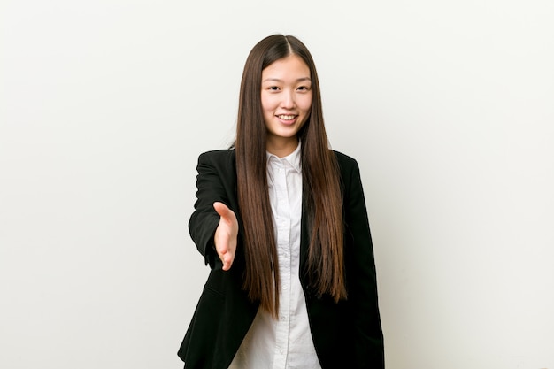 Jonge vrij Chinese bedrijfsvrouwen uitrekkende hand bij in groetgebaar.