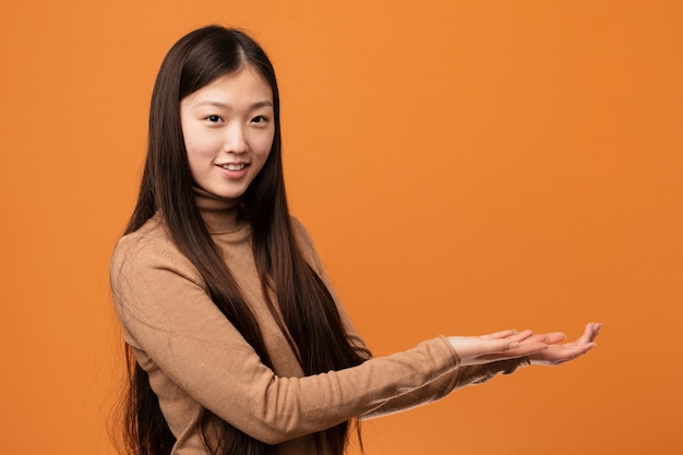 Jonge vrij Chinese vrouw die een exemplaarruimte op een palm houdt.