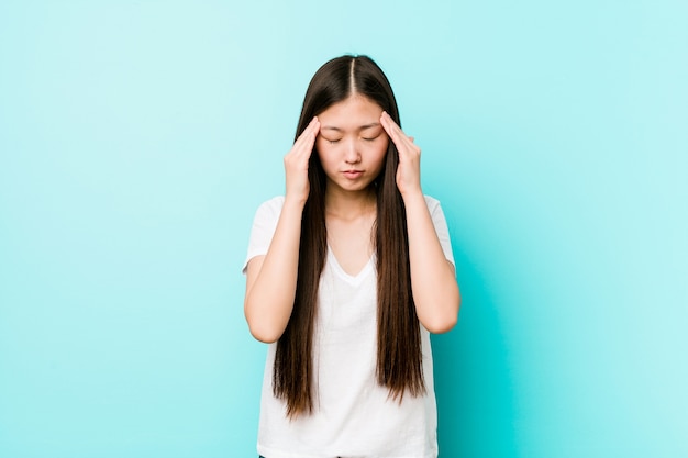 Jonge vrij chinese vrouw tempels aan te raken en hoofdpijn te hebben.