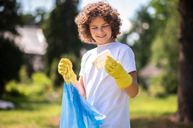 Jonge vrijwilliger met zakken vol [plastic afval