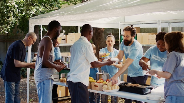 Jonge vrijwilligers uit Kaukasische en Afro-Amerikaanse gemeenschappen geven de minder bedeelden gratis voedsel en benodigdheden. Vrijwilligers die humanitaire hulp en hongerverlichting bieden aan de behoeftigen. Handbediend.