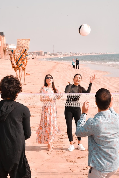 jonge vrolijke gelukkige koppels die voetbal spelen op het Indiase Pakistaanse strandmodel