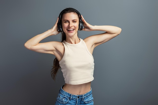 Jonge vrolijke vrouw geniet van muziek met een koptelefoon