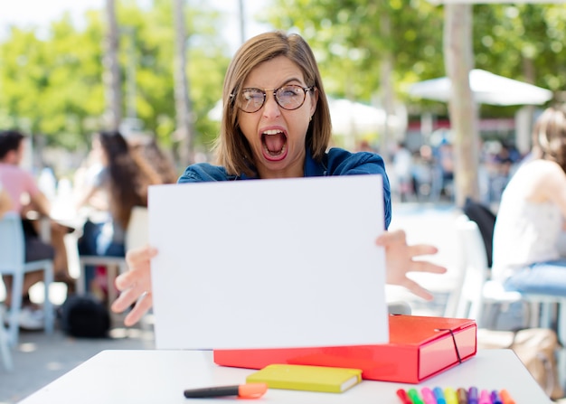 Foto jonge vrouw aan de universiteit met een bordje