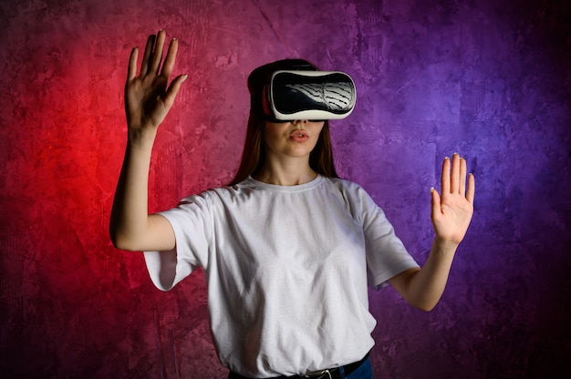 Jonge vrouw aanraken van de lucht tijdens de VR-ervaring. Blauwe en rode muur