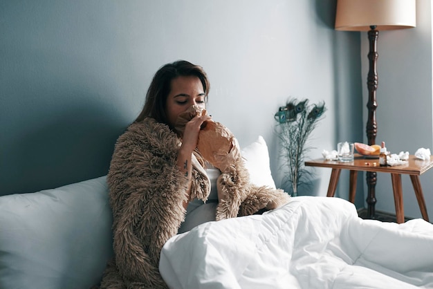 Foto jonge vrouw ademt in een papieren zak op bed thuis