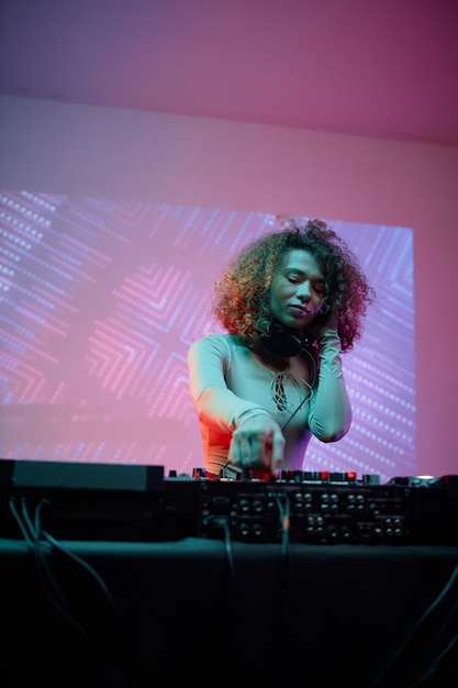 Jonge vrouw als vrouwelijke dj op discofeestje
