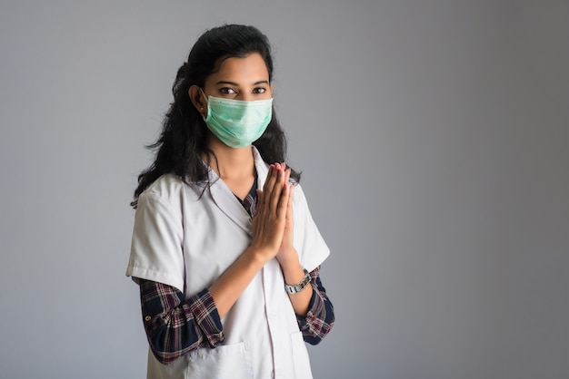 Jonge vrouw Arts die Namaste doet vanwege het uitbreken van COVID-19. Nieuwe begroeting om de verspreiding van het coronavirus te voorkomen in plaats van te begroeten met een knuffel of handdruk.