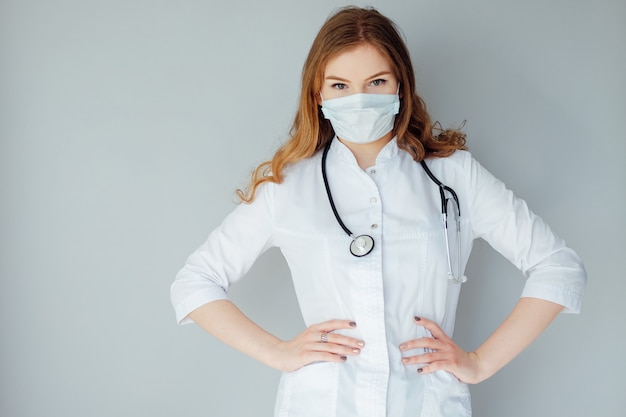 Jonge vrouw arts in een witte jas en een medisch masker. Het medicijn