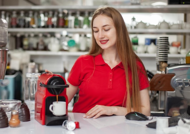 Jonge vrouw barista die koffie maakt in een koffiemachine