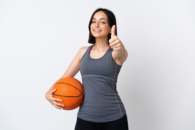 Jonge vrouw basketbal spelen geïsoleerd met duimen omhoog omdat er iets goeds is gebeurd