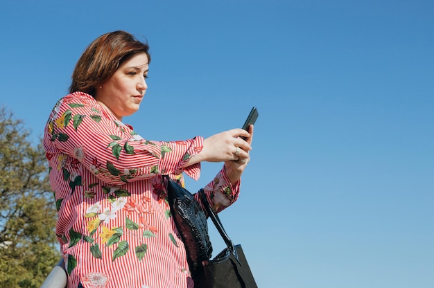 Jonge vrouw belt buiten een taxi na het winkelen