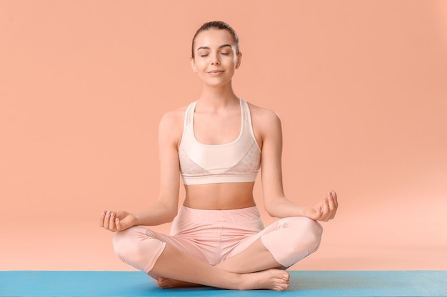 Jonge vrouw beoefenen van yoga op kleur