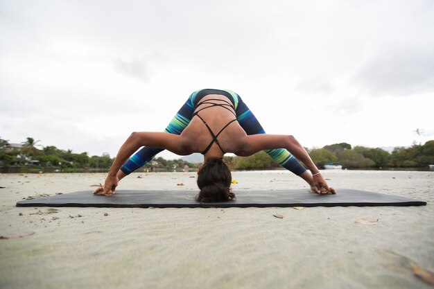 Jonge vrouw beoefent yoga aan de oever van de Indische Oceaan