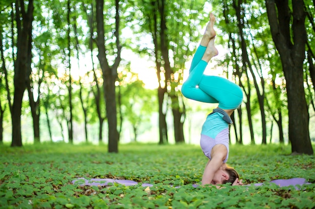 Jonge vrouw beoefent yoga in een groen bos