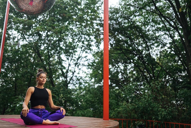 Jonge vrouw beoefent yoga zittend in de lotuspositie