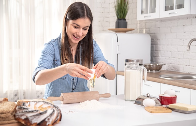 Jonge vrouw bereiden zelfgemaakte taarten in de ruime lichte keuken.