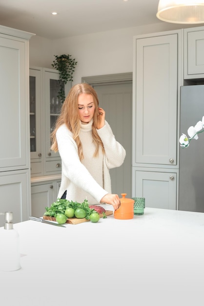 Jonge vrouw bereidt zich voor in de keuken Gezonde voeding Salade Dieet Op dieet zijn Concept Gezonde levensstijl Thuis koken Bereid voedsel Snijdende ingrediënten op tafel