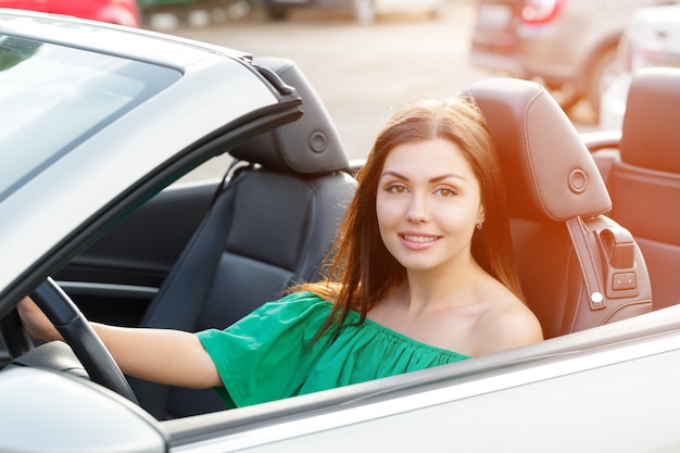 Jonge vrouw besturen van een auto in de stad.