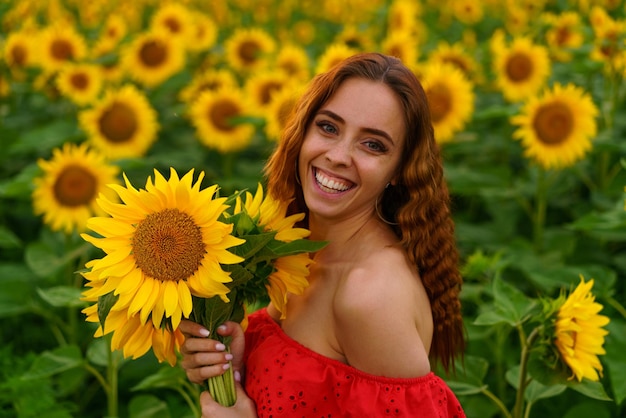 Jonge vrouw bij zonsondergang poseert in een veld van zonnebloemen vrijheid concept