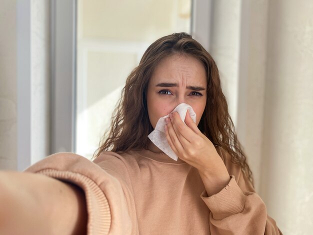 Jonge vrouw blijft thuis geïsoleerd met tekenen van een virale infectie