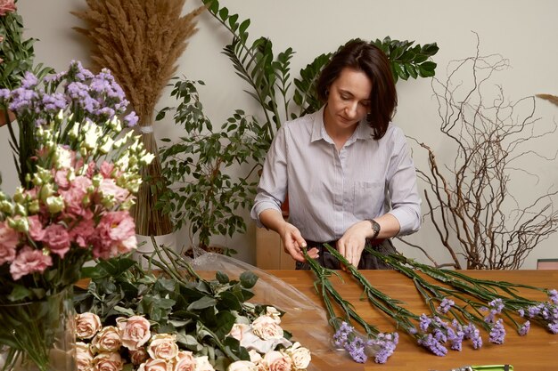 Jonge vrouw bloemist in haar studio een mooi boeket maken