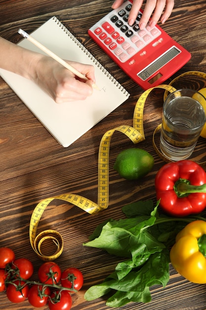 Jonge vrouw calorieën berekenen aan tafel Gewichtsverlies concept