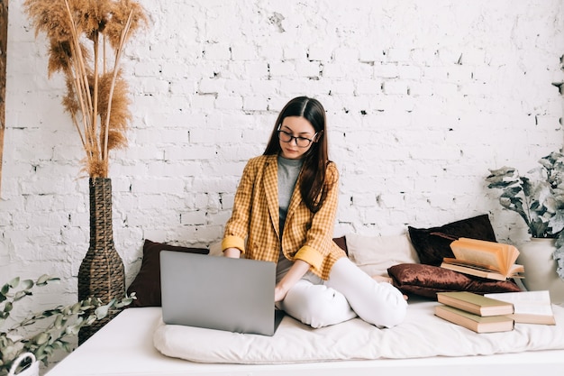 Jonge vrouw college student in bril studeren met laptop