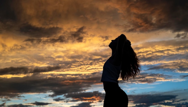 Jonge vrouw dansen in de zomer avondrood buiten. Mensen vrijheid stijl.