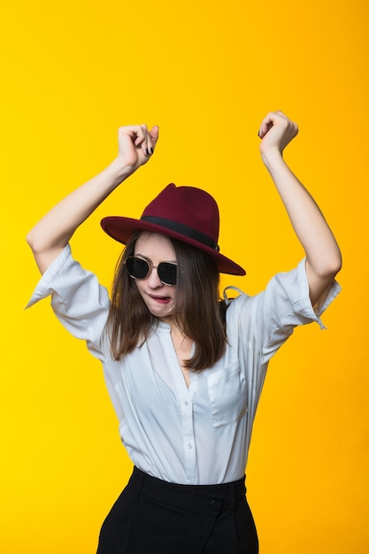 Jonge vrouw dansen op gele achtergrond