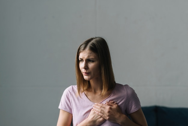 Foto jonge vrouw die aan borstpijn lijdt