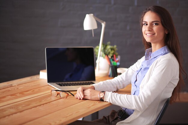 Jonge vrouw die aan een bureau werkt