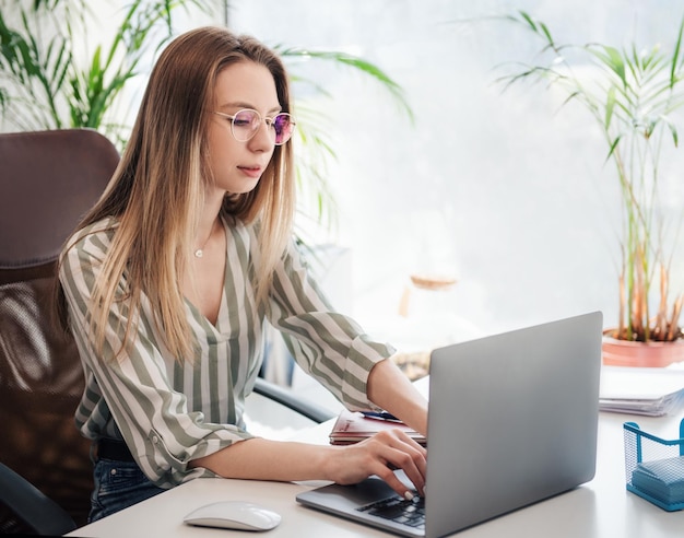 Jonge vrouw die aan een computer werkt