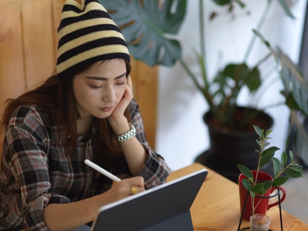 Jonge vrouw die aan een digitale tablet werkt