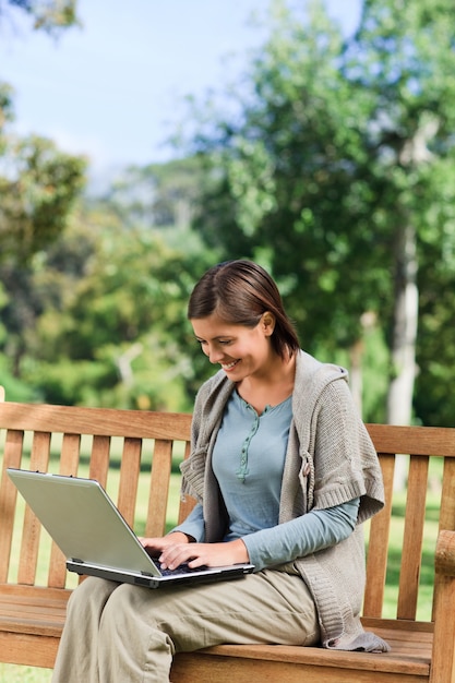 Jonge vrouw die aan haar laptop werkt