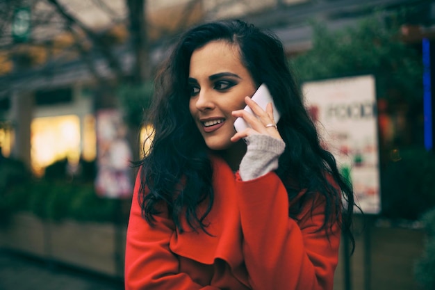Jonge vrouw die aan het bellen is in de stad.