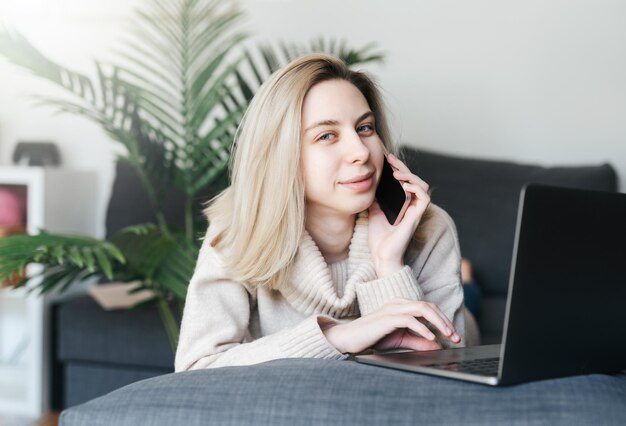 Jonge vrouw die aan laptop in huis werkt