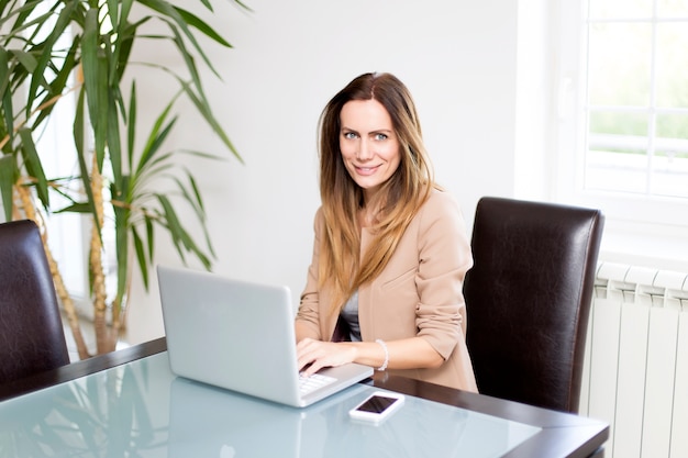 Jonge vrouw die aan laptop werkt