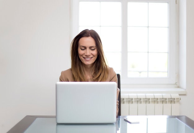 Jonge vrouw die aan laptop werkt