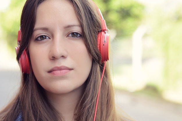 Jonge vrouw die aan muziek luistert