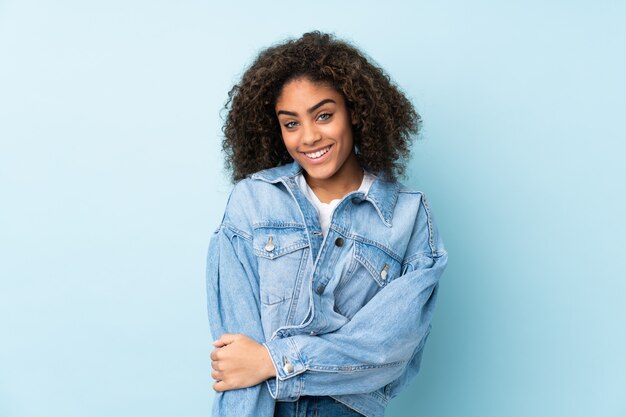 Jonge vrouw die bij het blauwe muur lachen wordt geïsoleerd