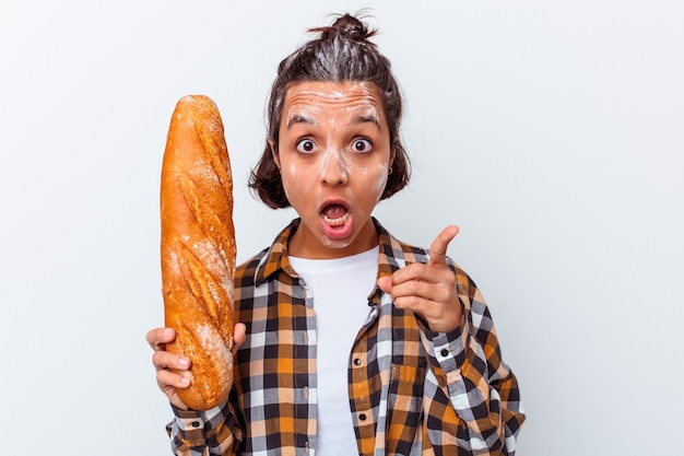 Jonge vrouw die brood maakt dat op witte muur wordt geïsoleerd die een idee heeft